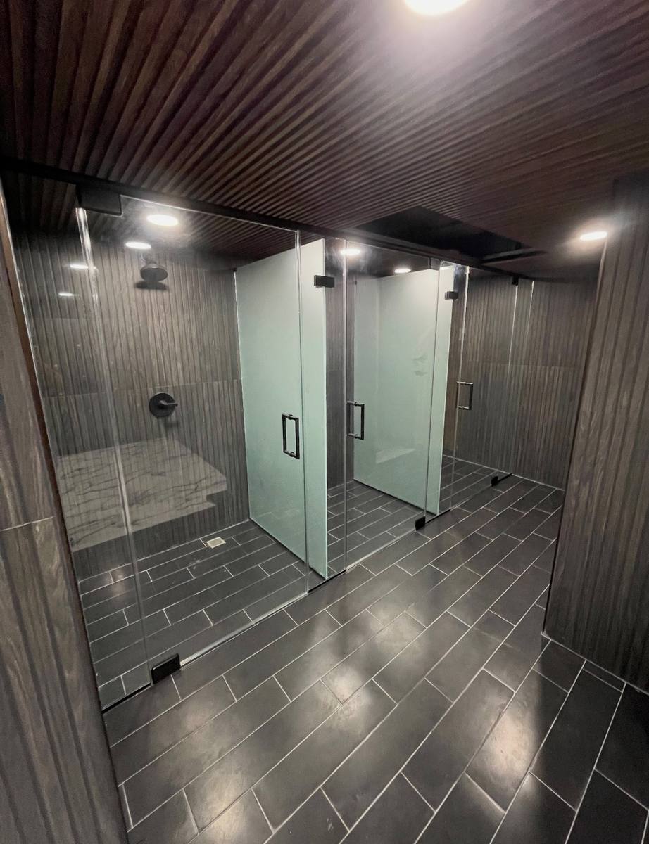 Frameless hinged shower enclosure with frosted panels and matte black hardware