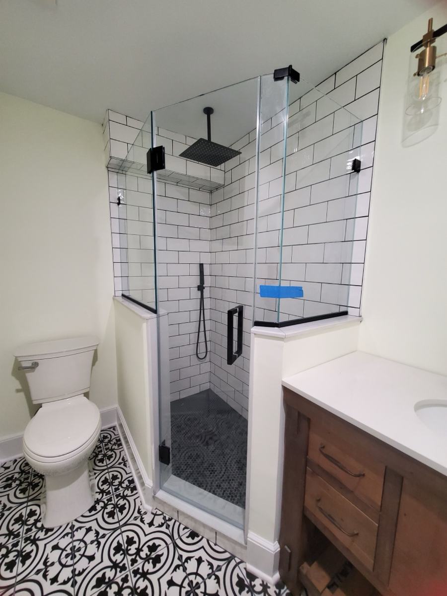 Frameless neo-angle shower enclosure with matte black hardware