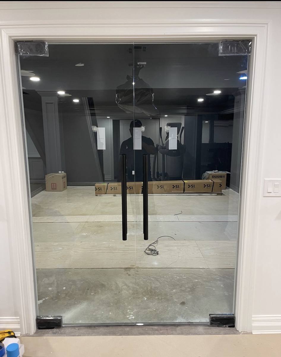 Frameless glass double doors with black pull handles