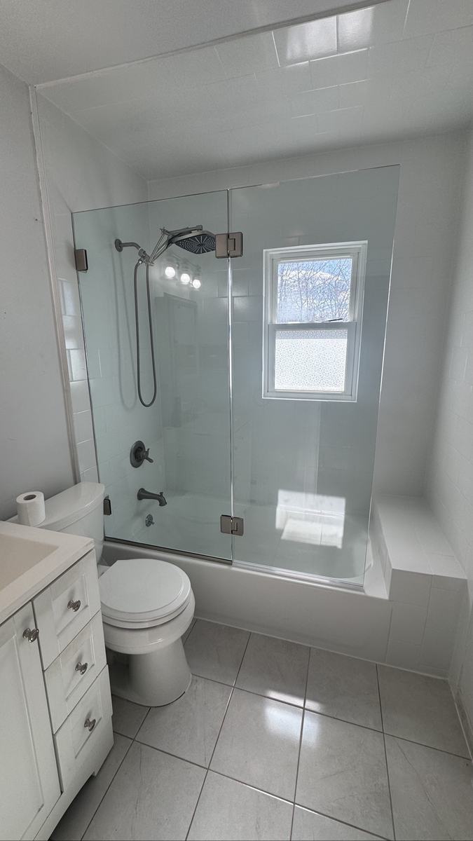 Frameless hinged tub shower door with chrome hardware