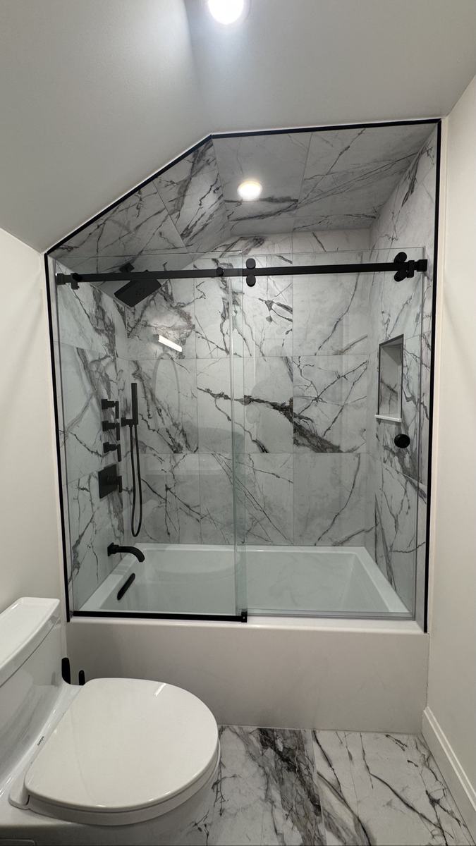 Frameless sliding tub enclosure with matte black hardware