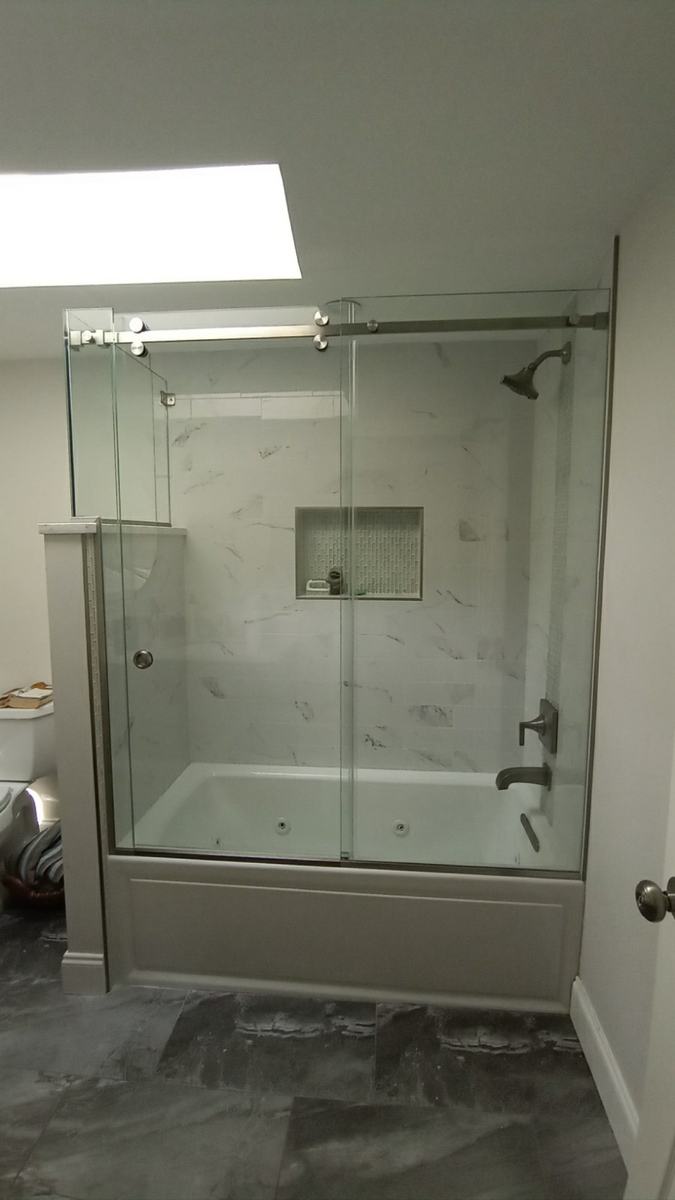 Frameless sliding tub enclosure with chrome hardware