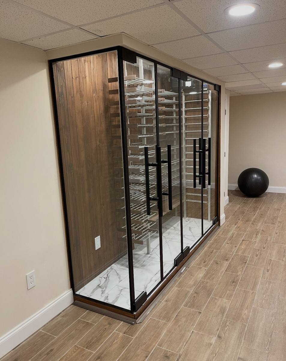 Black-framed glass wine cellar with wood paneling