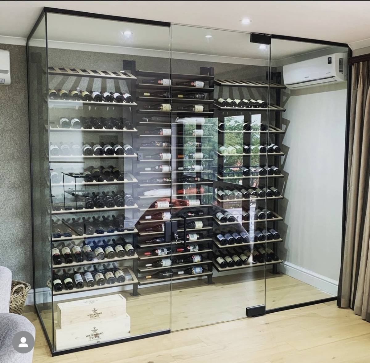 Black-framed glass wine cellar enclosure with metal racking